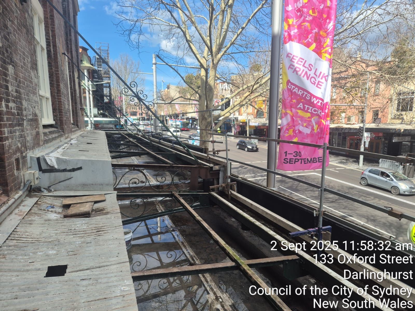 Damaged sidewalk and exposed construction area beside a street on a sunny day