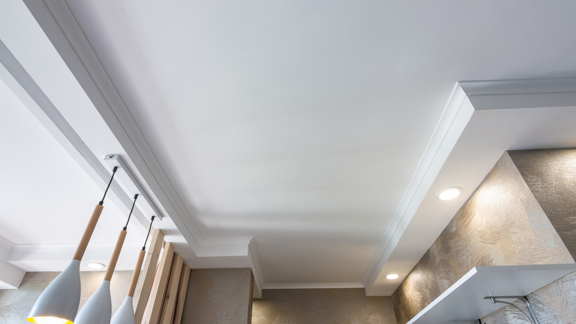 Modern interior ceiling with crown molding, recessed lights, and a tall window with curtains