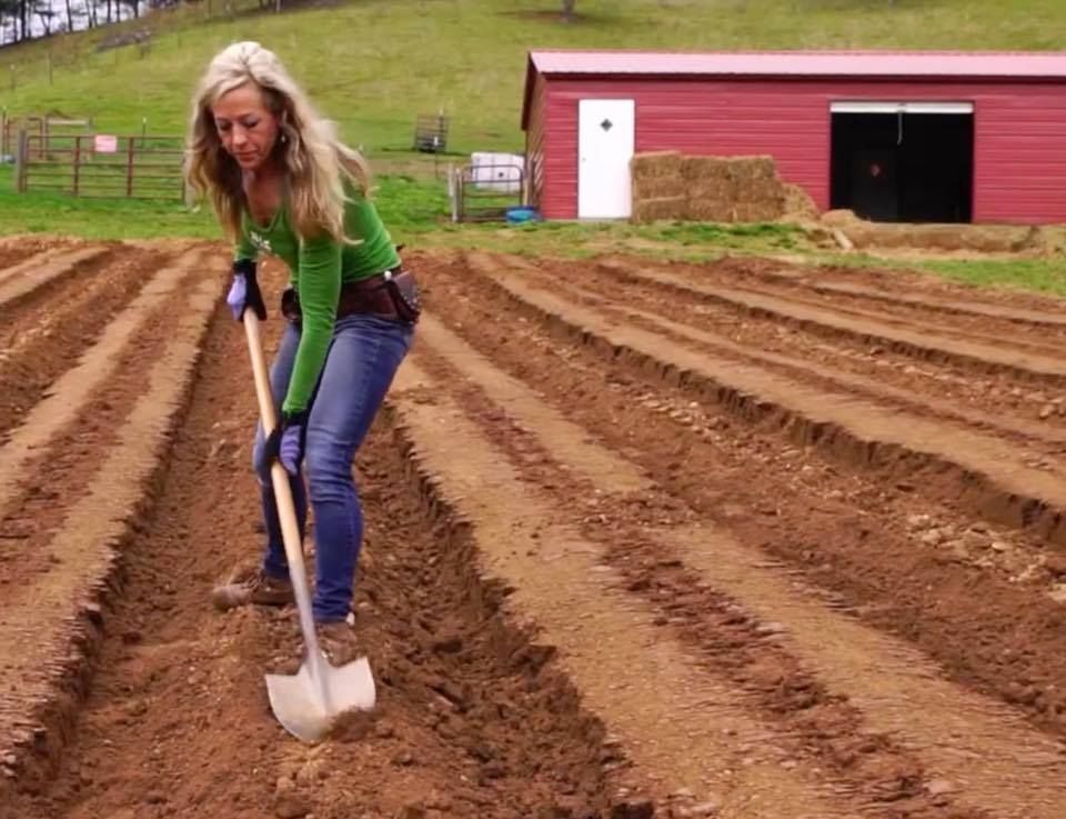 Founder and CEO of Franny's Farmacy digging garden beds with a shovel on the farm