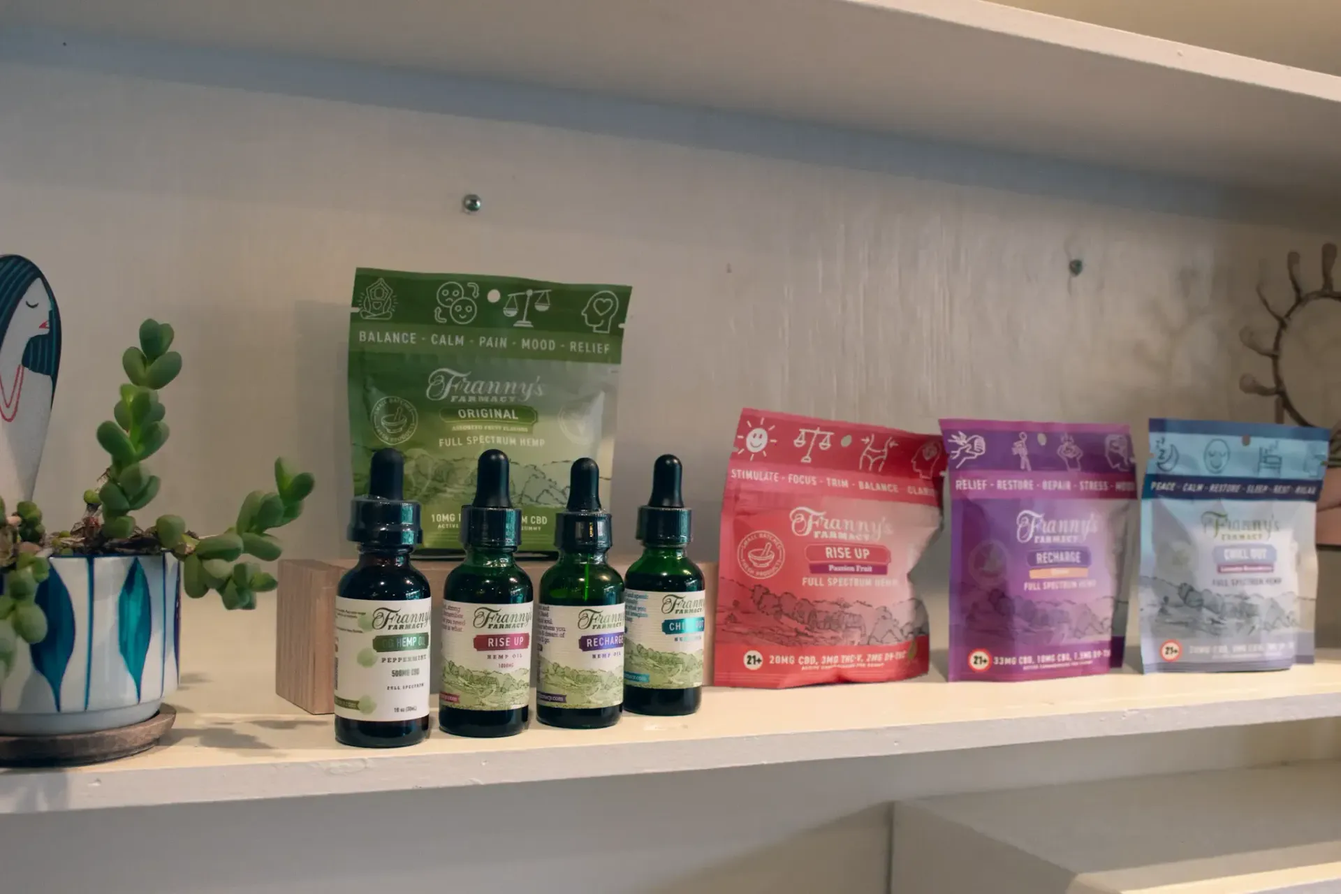 Various hemp products on a shelf including CBD gummies, and thca and cbd tinctures