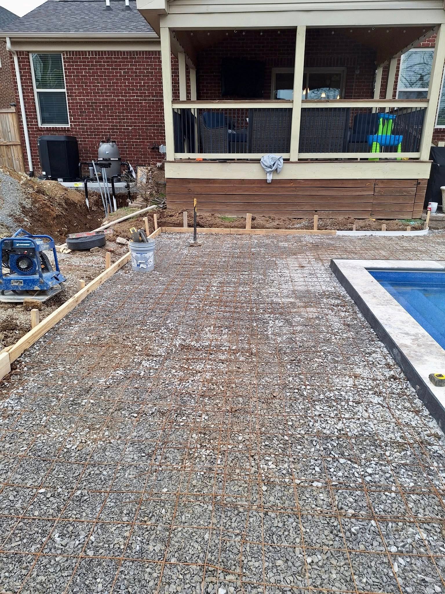 Gravel pathway leading to a brick house porch with steps and a blue-edged pool on the right.