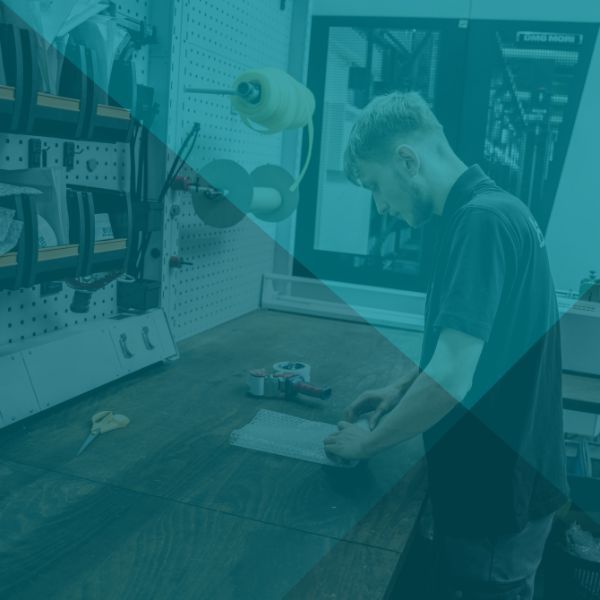 Im Inneren einer Produktionsstätte: CNC-Maschinen und ein Arbeiter.