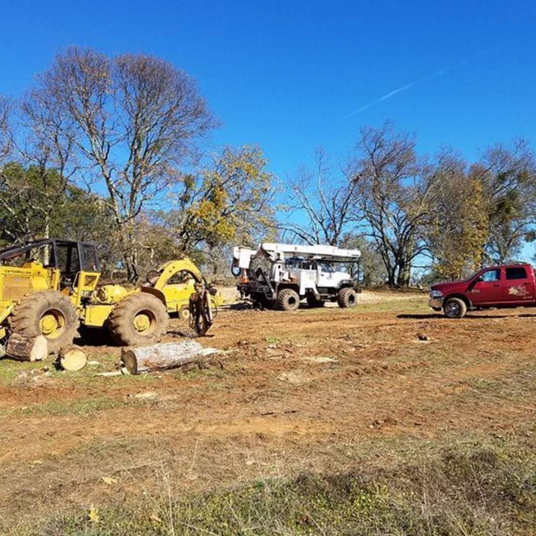 Construction equipment on a brown field under a clear blue sky, with a red pickup truck and a white jeep. Construction equipment on a brown field under a clear blue sky, with a red pickup truck and a white jeep.