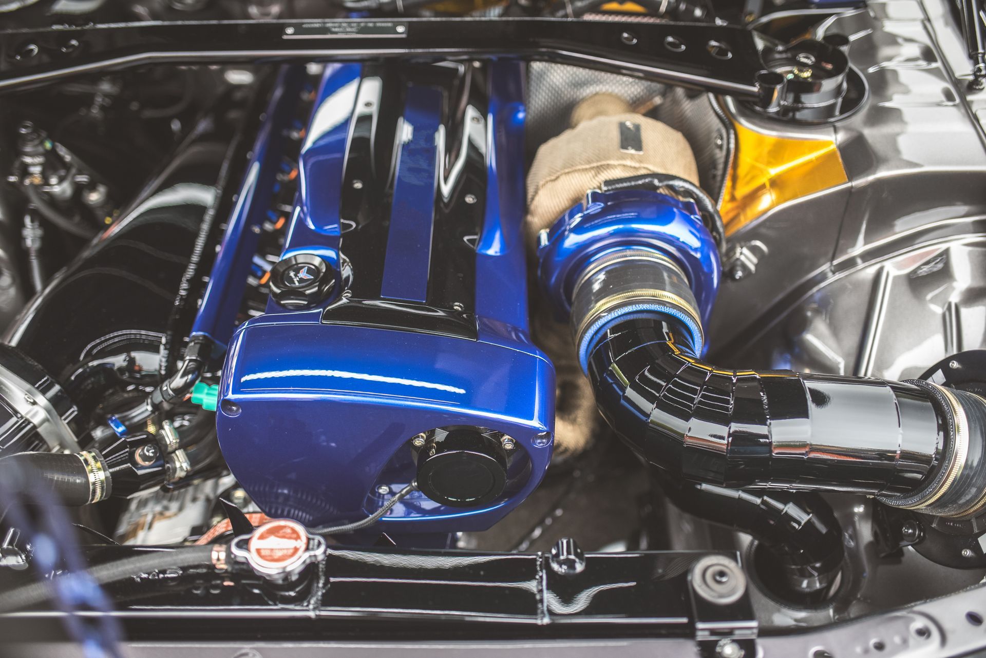 Blue and chrome car engine with visible turbocharger and polished components Blue and chrome car engine with visible turbocharger and polished components