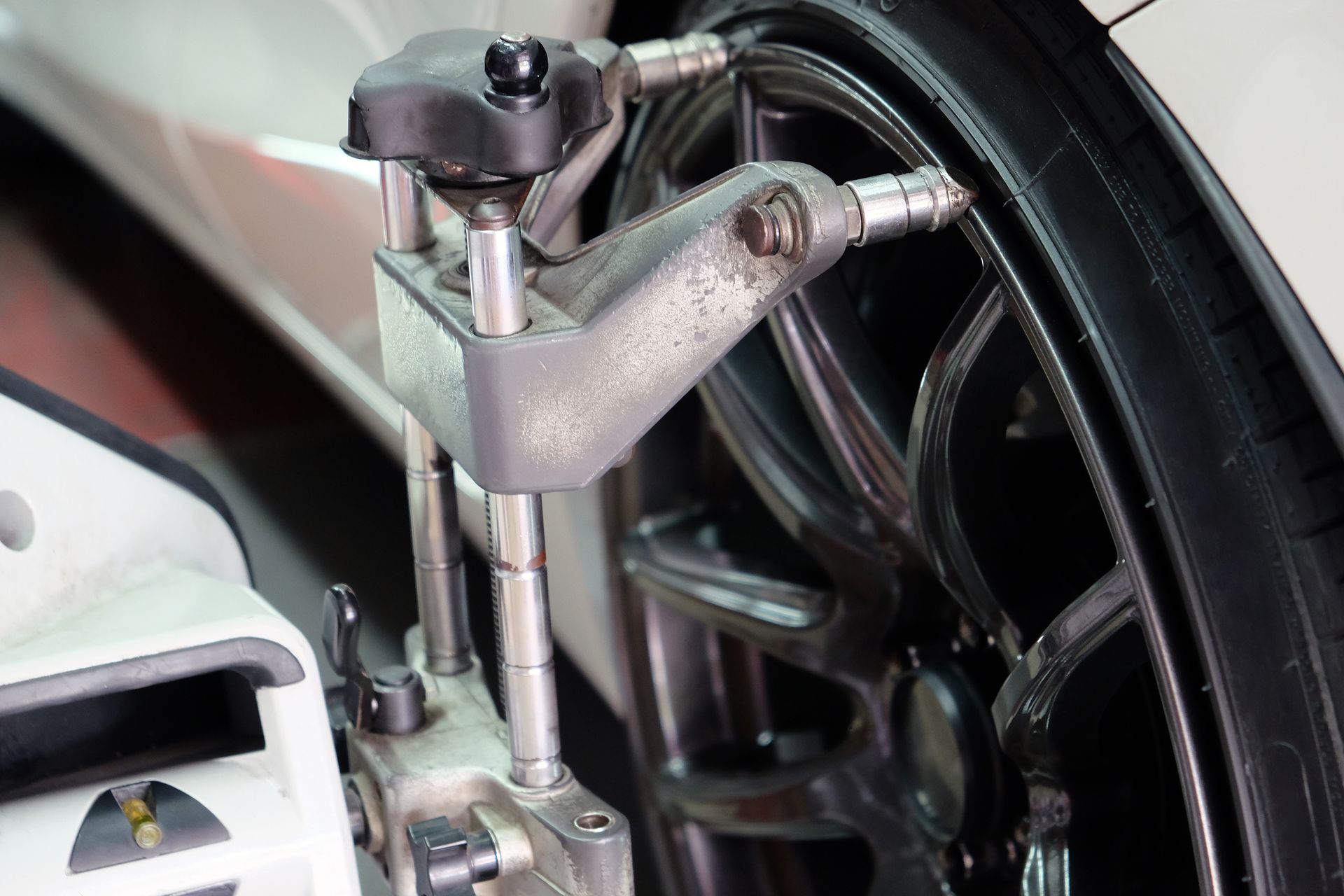 Close-up of a metal mechanical arm beside black tubing and a wheel assembly Close-up of a metal mechanical arm beside black tubing and a wheel assembly