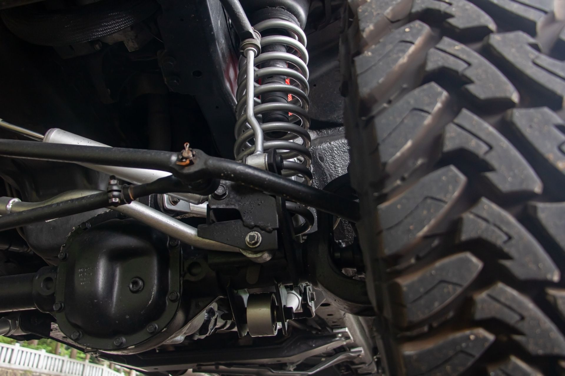 Close-up of a truck’s suspension and large off-road tire beneath the chassis Close-up of a truck’s suspension and large off-road tire beneath the chassis