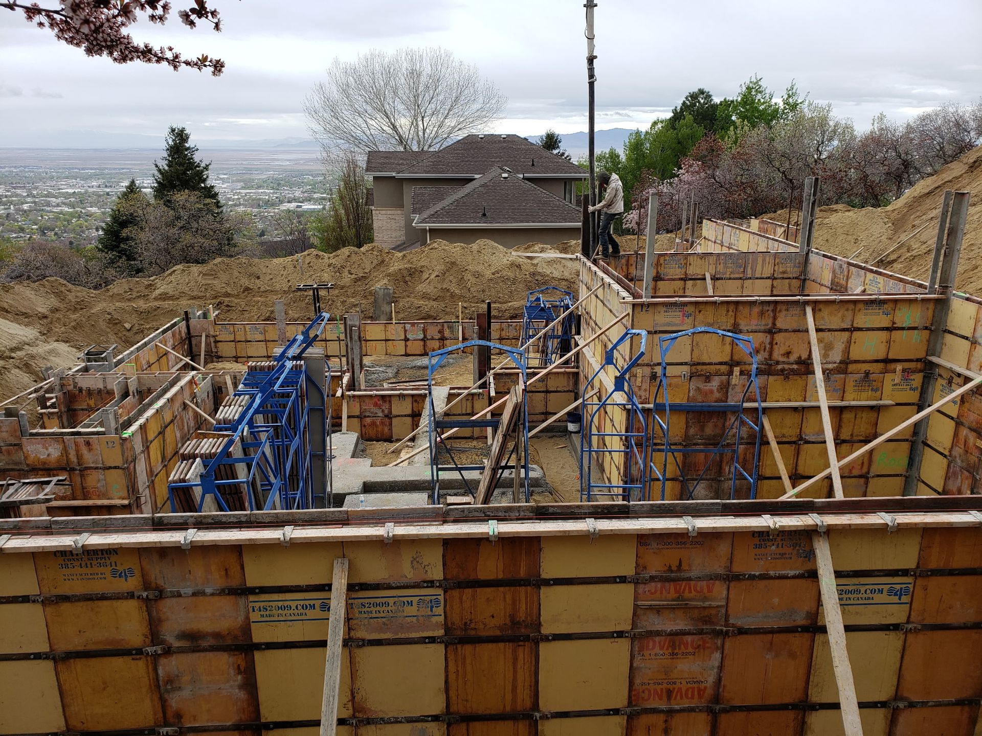 Wooden foundation forms and rebar at a construction site overlooking a distant valley