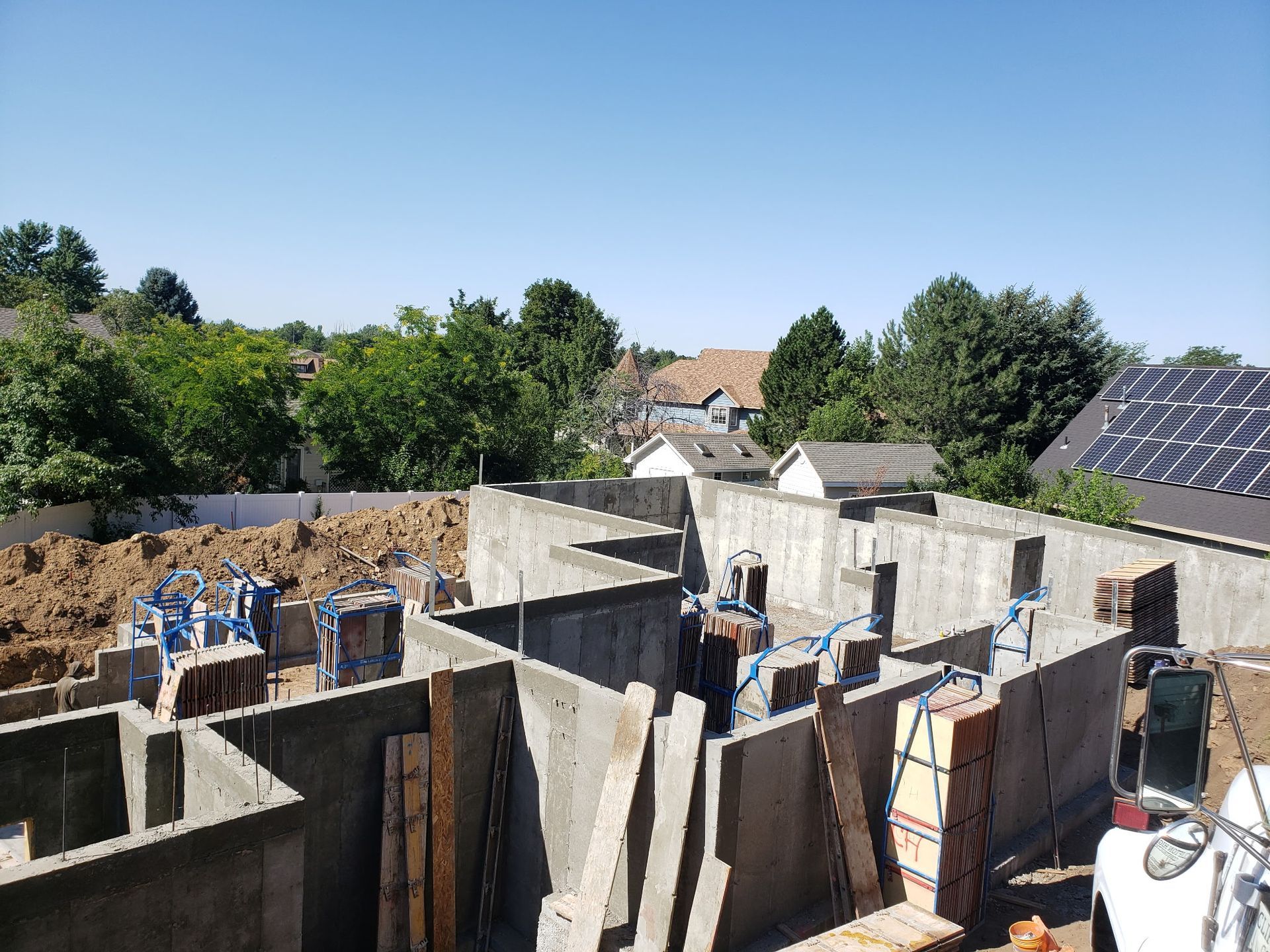 Partially built concrete house with solar panels under a clear blue sky