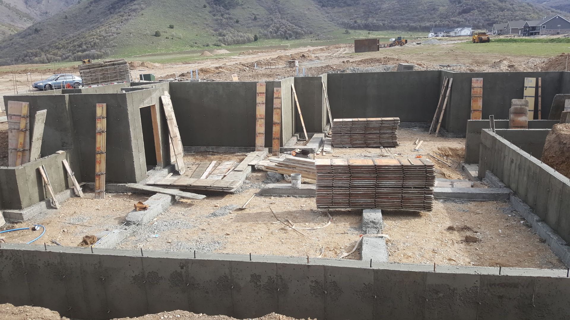 Partially built concrete structure with stacked bricks and surrounding mountain landscape