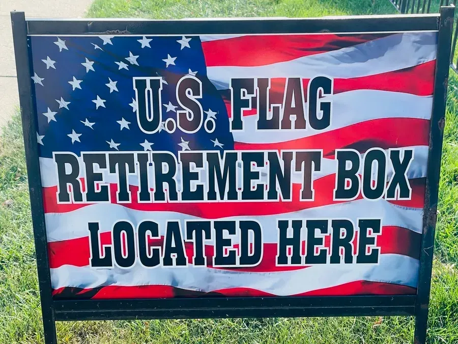 Sign for U.S. flag retirement box with red, white, and blue flag background