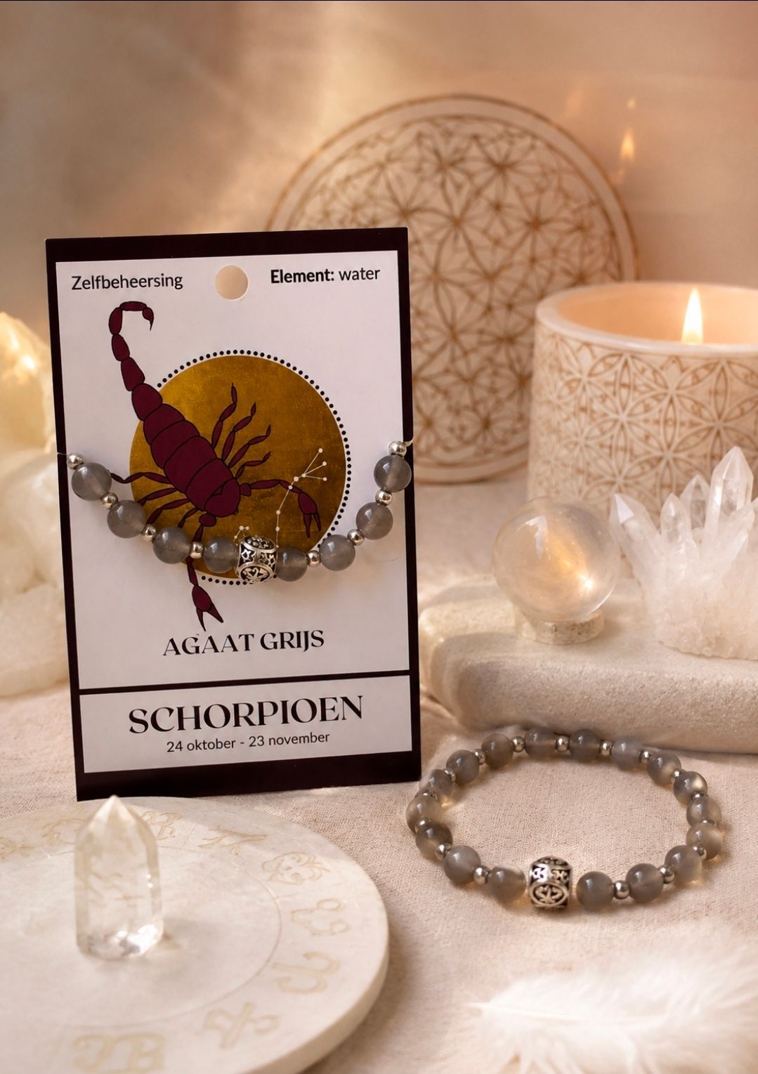 Een tarotkaart van het sterrenbeeld Schorpioen en een kristal en een kralenarmband op een zachte tafel.