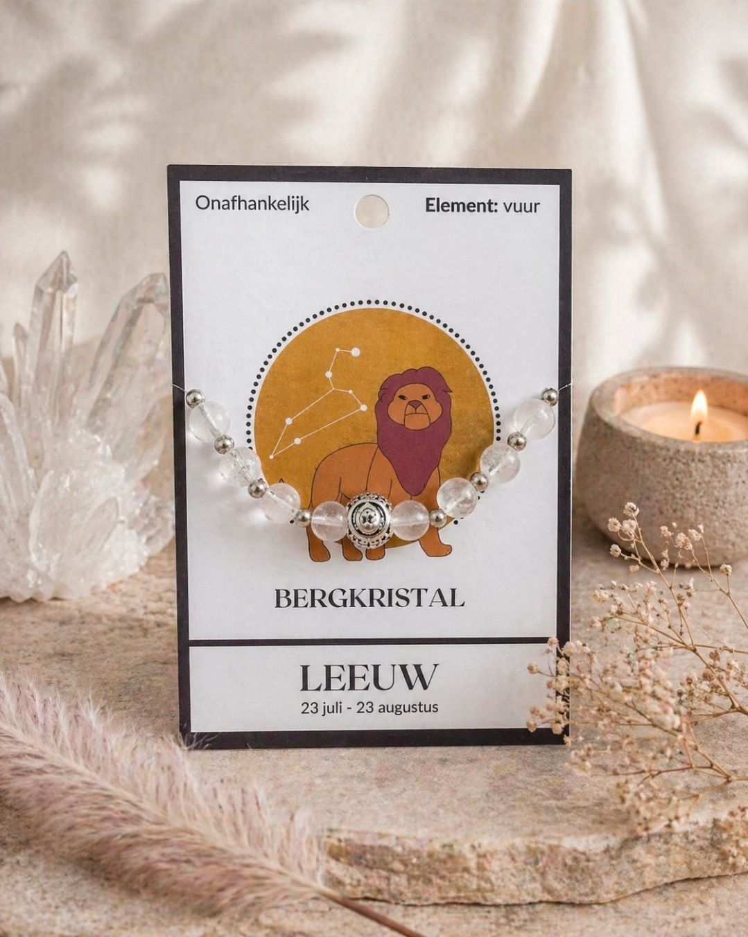 Verpakking van een kralenketting met kristallen op een displaykaart naast een brandende kaars en zachte decoratie.