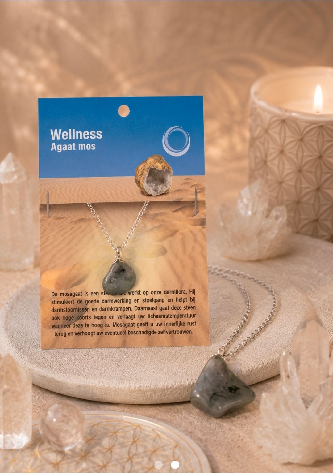 Een wellness-kristallenketting wordt tentoongesteld op een beige dienblad naast een brandende kaars en kleine kristallen.