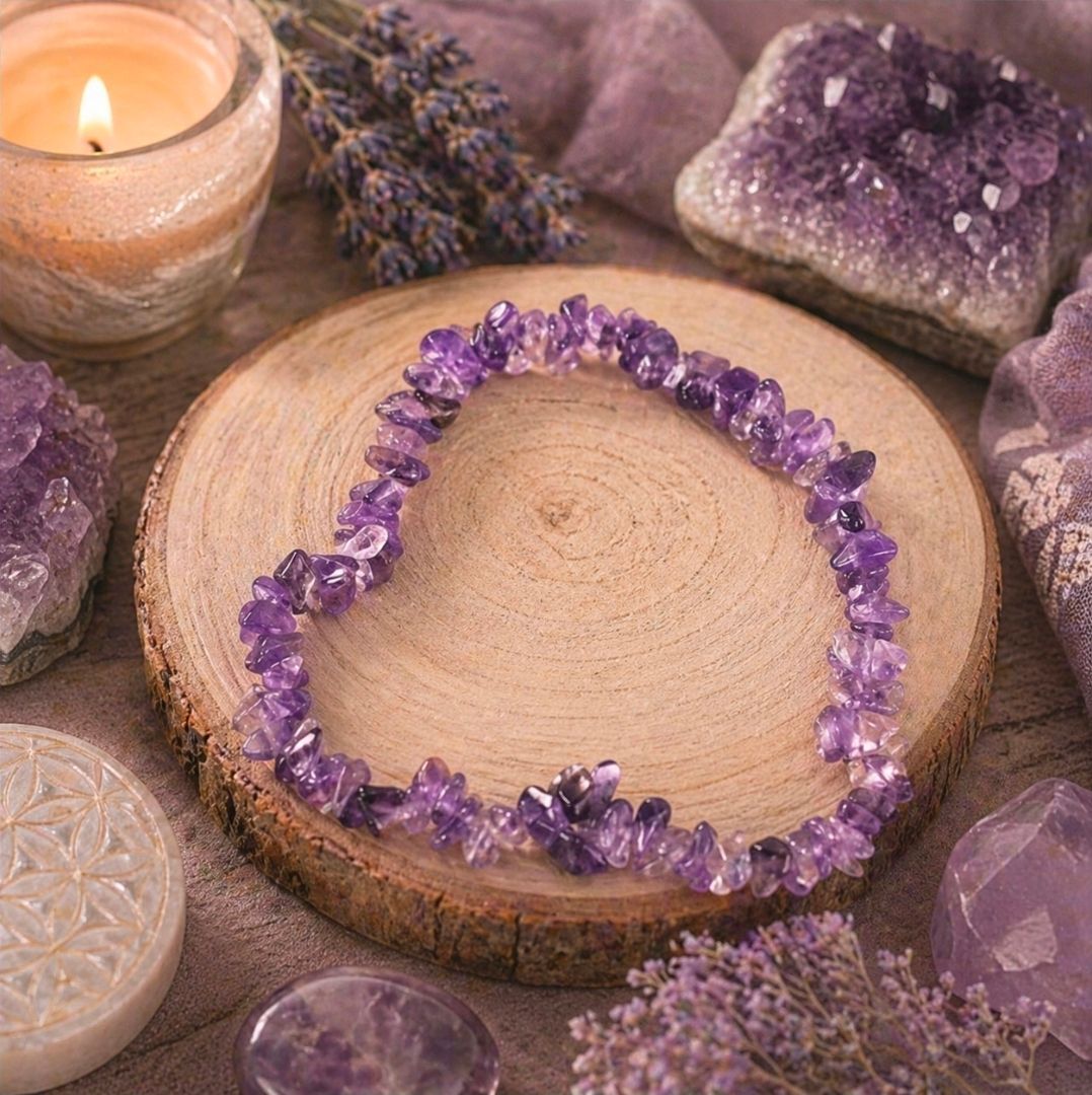 Paarse kristallen armband op een houten schijf, omringd door lavendelkleurige stenen en een brandende kaars.