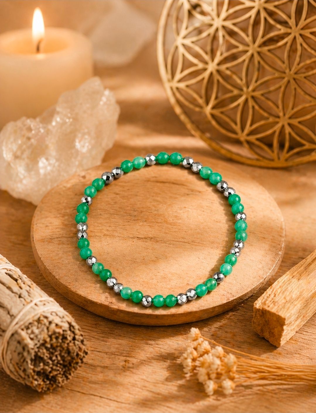 Groene kralenarmband op een houten schaal met kaarsen en spa-decoratie.