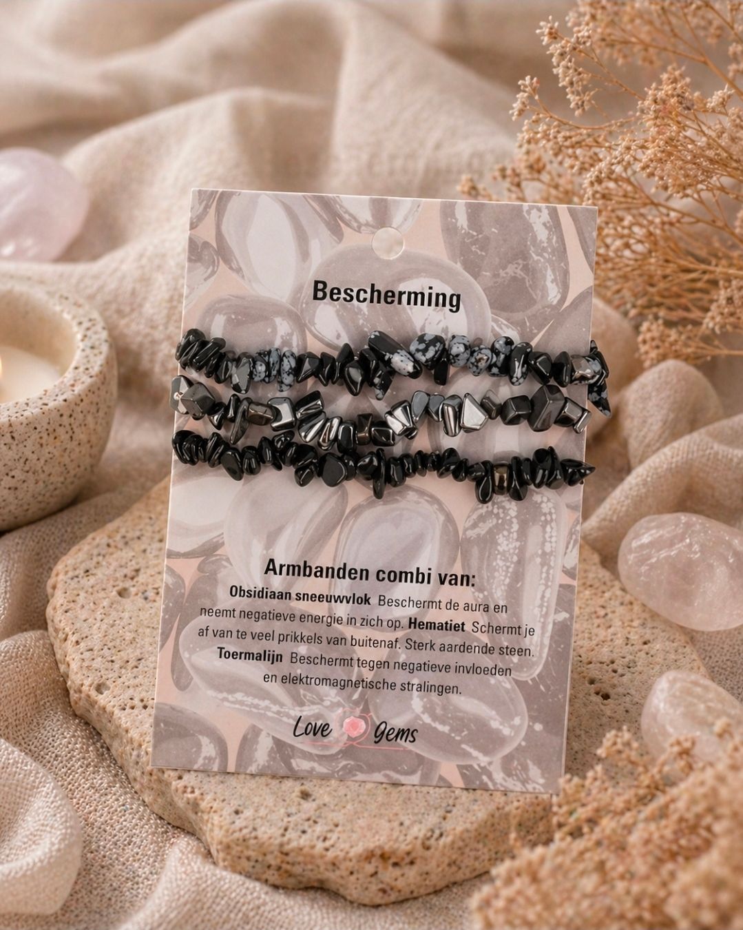 Diverse zwarte kralenarmbandjes op een presentatiekaartje met een roze hartje, geplaatst