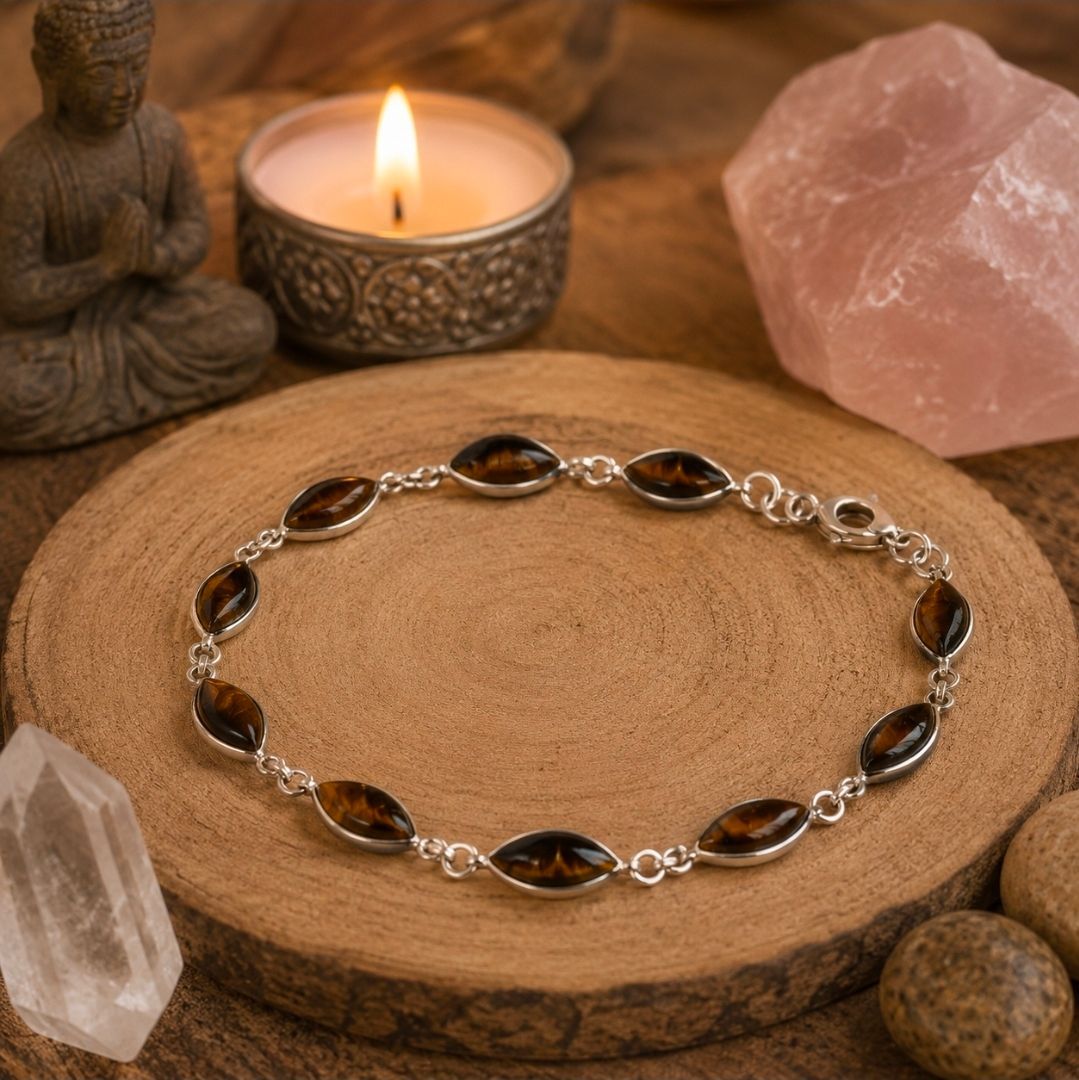 Armband met donkere stenen op een houten schijfje naast een kaars, rozenkwarts en kristallen.