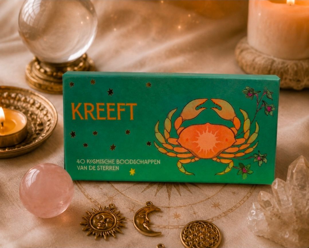 Groene KREEFT-doos met oranje krabembleem op een sfeervol verlichte tafel met kaarsen en kristallen.