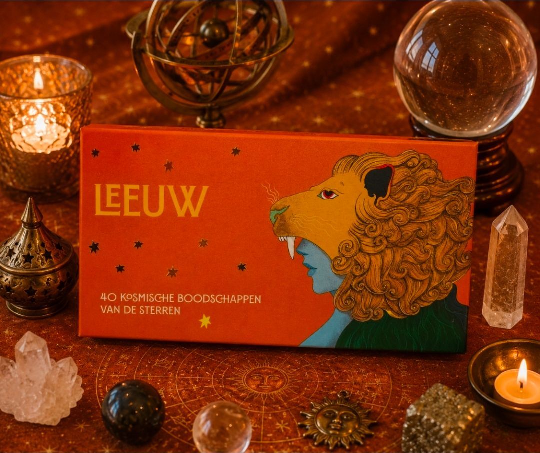 Een geïllustreerd boek in oranje en turquoise op een tafel bij kaarslicht, omringd door kristallen en decoratieve objecten.