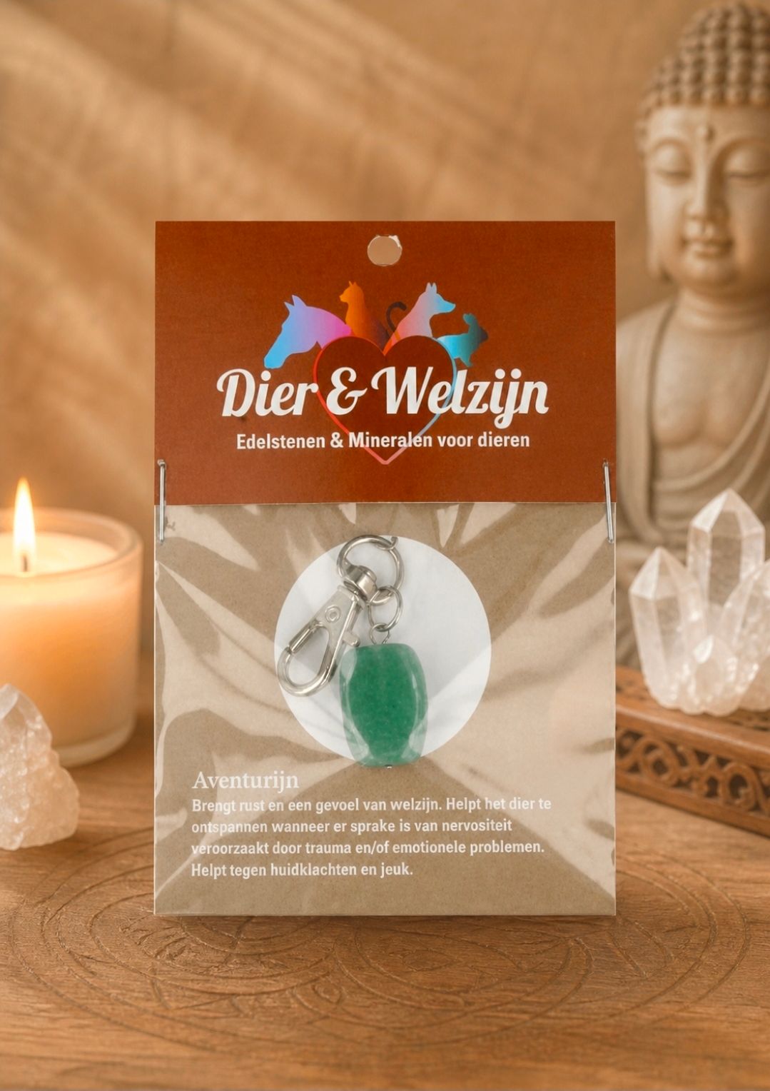 Dier & Welzijn verpakking met kristallen hanger en groene steen, verlicht door kaarsen naast een Boeddhabeeld en kristallen.