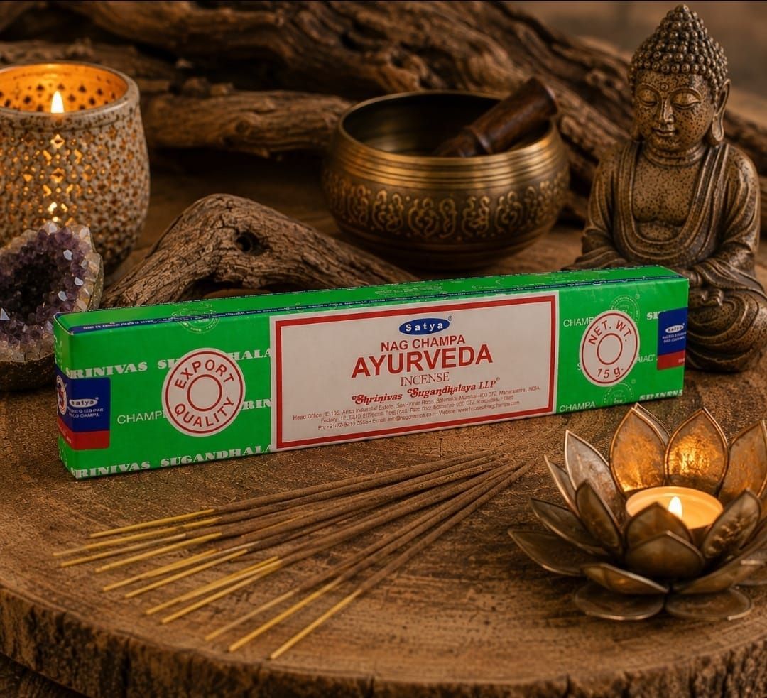 Een doos met Ayurvedische producten op een rustieke houten ondergrond met kaarsen, een Boeddhabeeld en spa-decoratie.