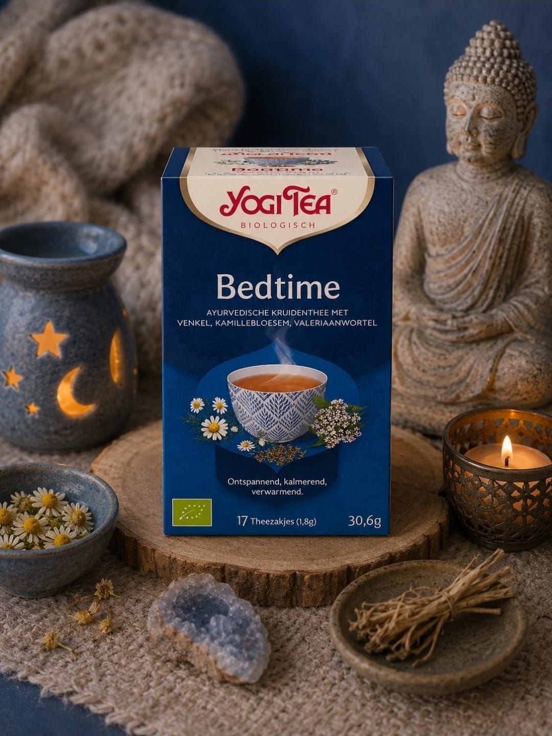 Yogi Tea Bedtime-box met een Boeddhabeeldje, kaarsen en een theekopje op een gezellig tafeltje.
