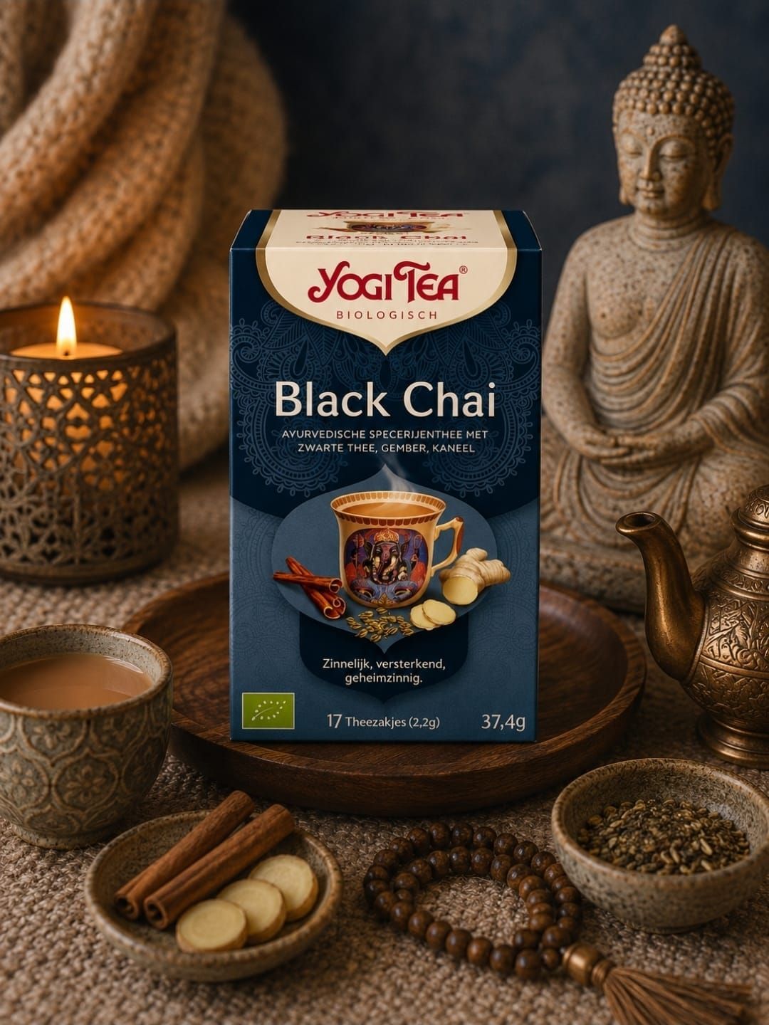 Een doos Yogi Tea Black Chai op een gezellig tafeltje met kaarsen, kruiden en een Boeddhabeeld.
