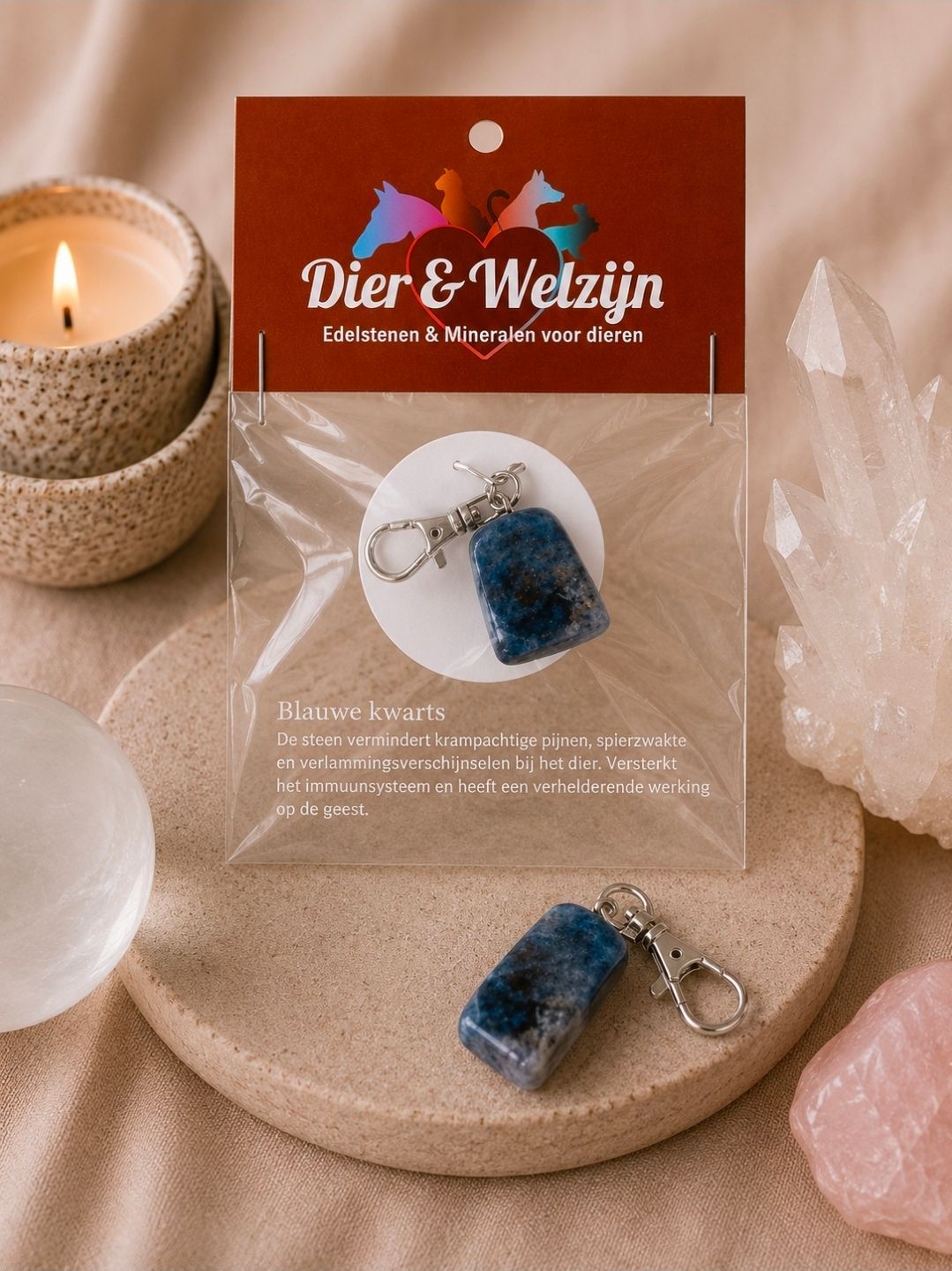 Sieradenpresentatiekaart met blauwe kristallen hanger en kaars op een beige stoffen achtergrond.