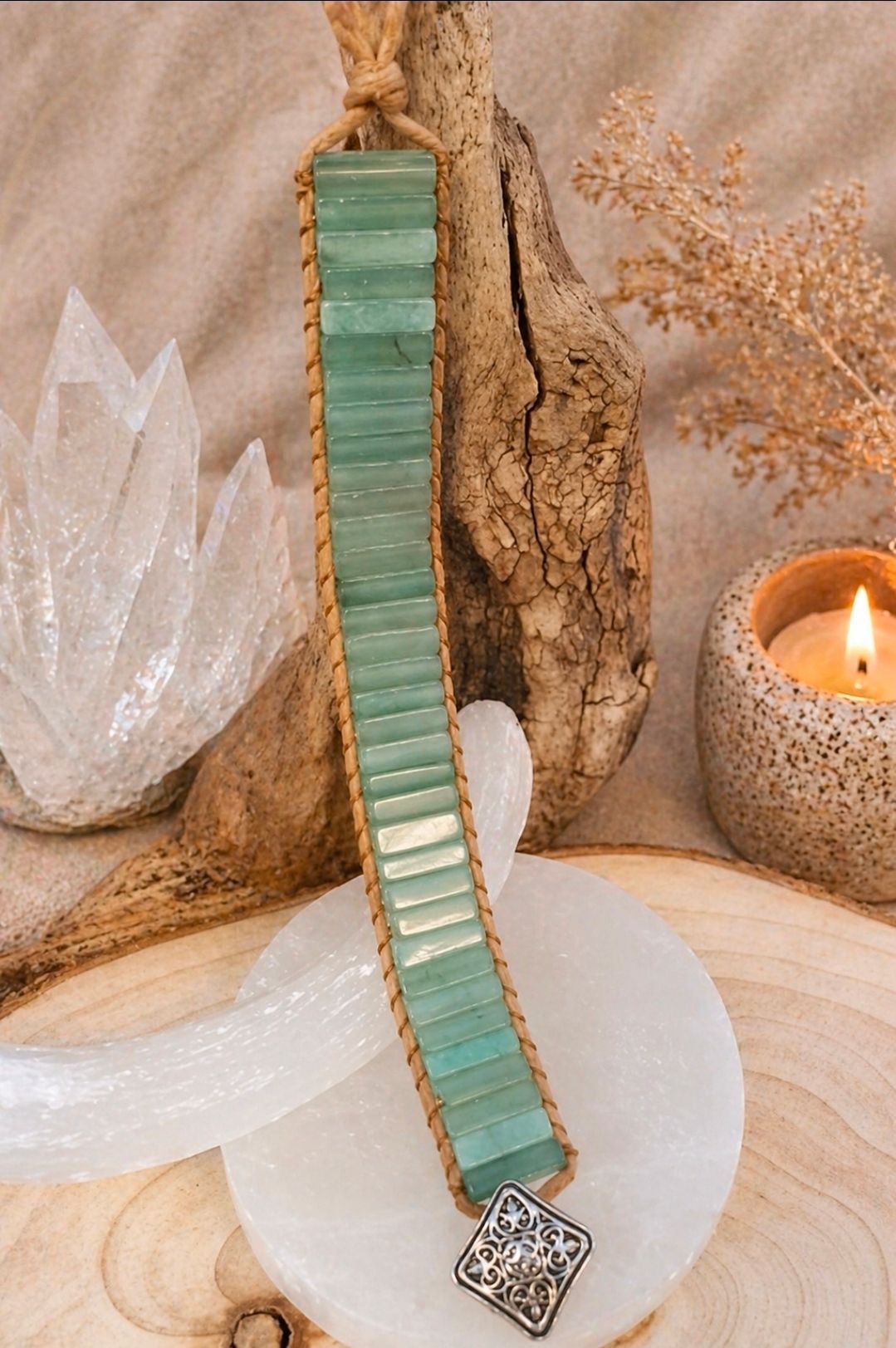 Mintgroene armband met een gouden kettingsluiting, tentoongesteld in boho-stijl met een kaars en kristallen.
