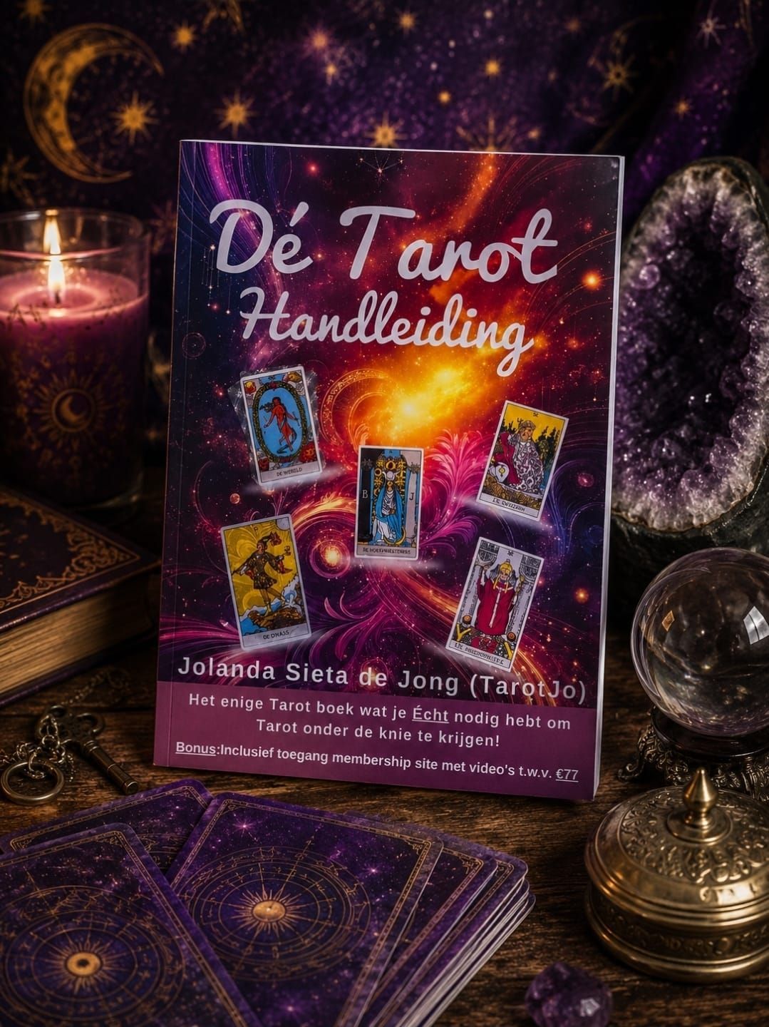 Een paarse doos met tarotkaarten op een tafel bij kaarslicht, omringd door kaarten, kristallen en een messing kaarsenhouder.