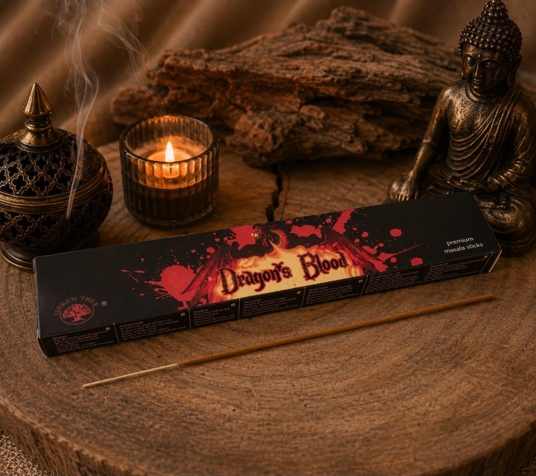 Een doosje Dragon's Blood wierook op een houten tafel met kaarsen en Boeddhabeelden.
