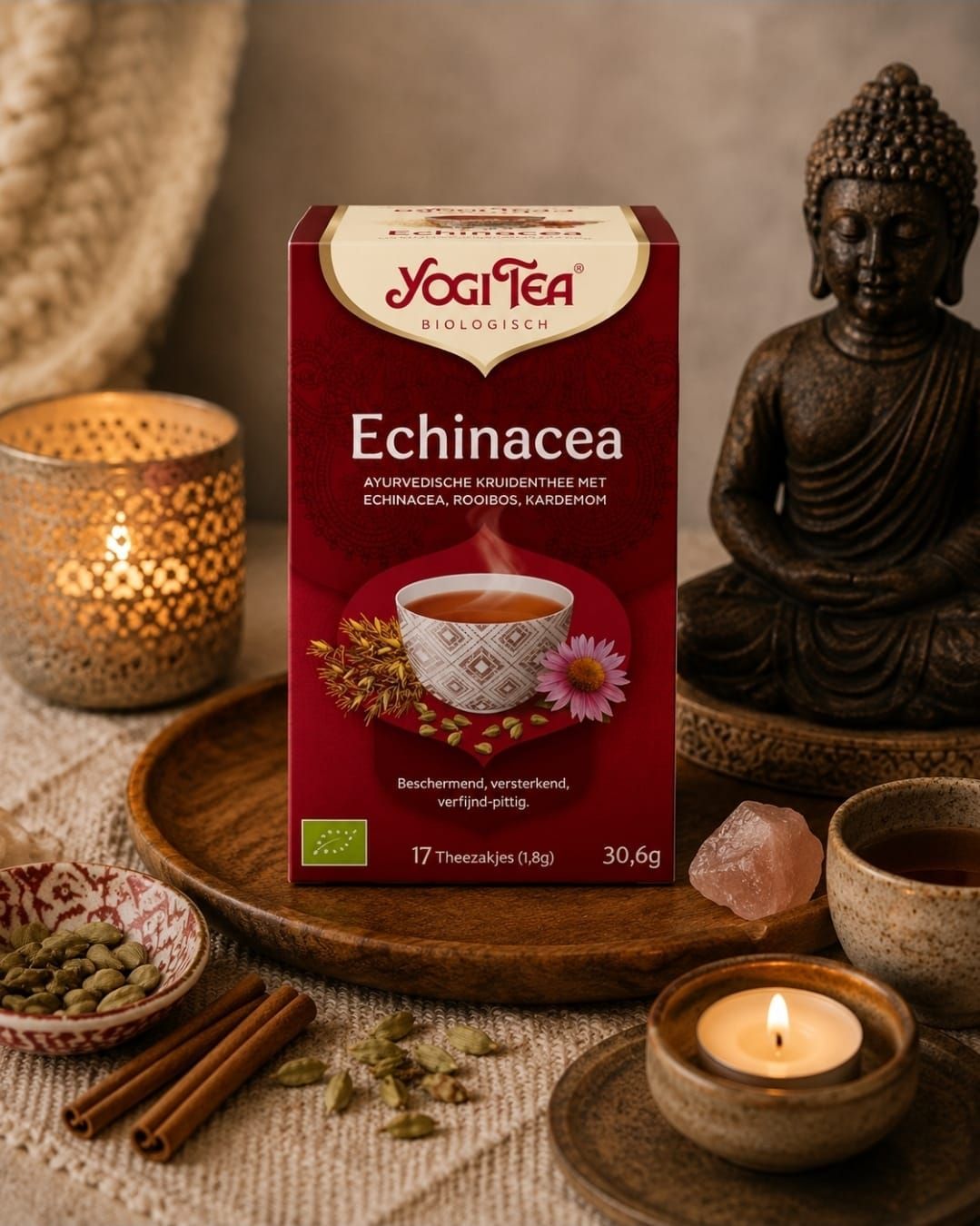 Yogi Tea Echinacea-doos op een houten dienblad met kaars, kaneelstokjes, kruiden en een Boeddhabeeldje