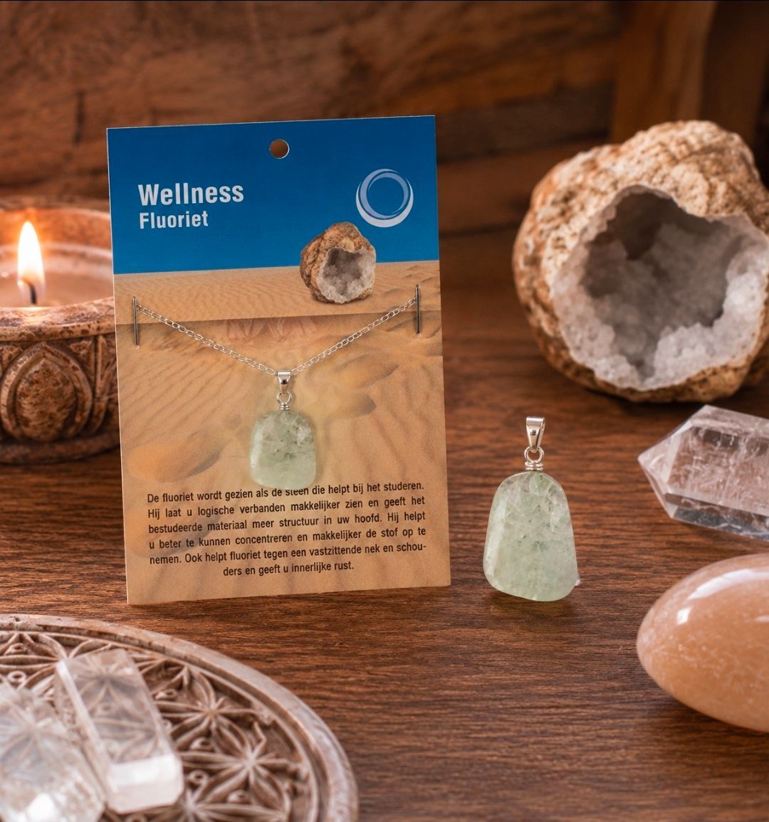 Wellness-halsketting van fluoriet, gepresenteerd op een blauw-beige kaart met steentjes en kristallen als decoratie.