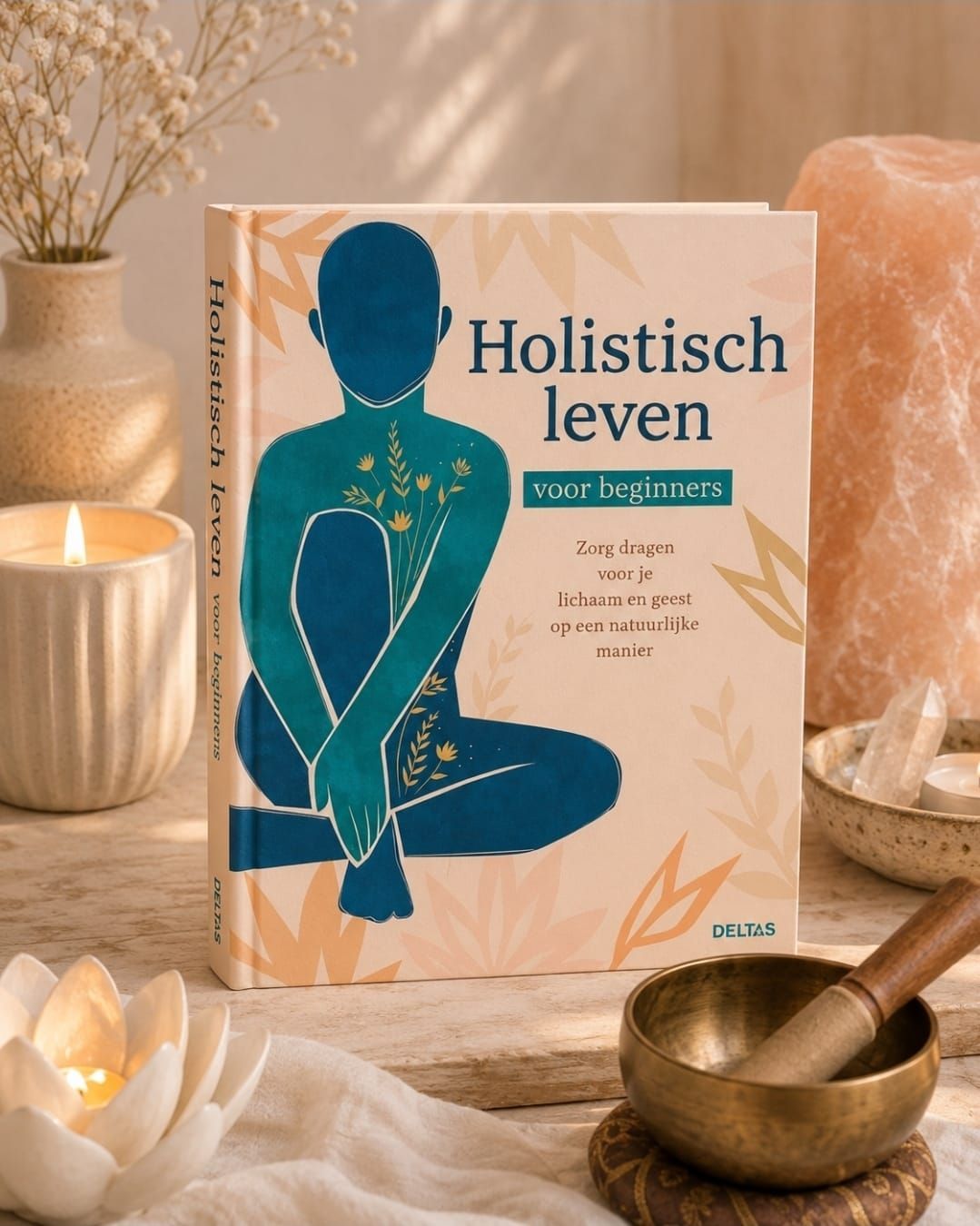 Het Nederlandse boek “Holistisch leven” ligt op een warme tafel bij kaarslicht, met kristallen en een klankschaal.