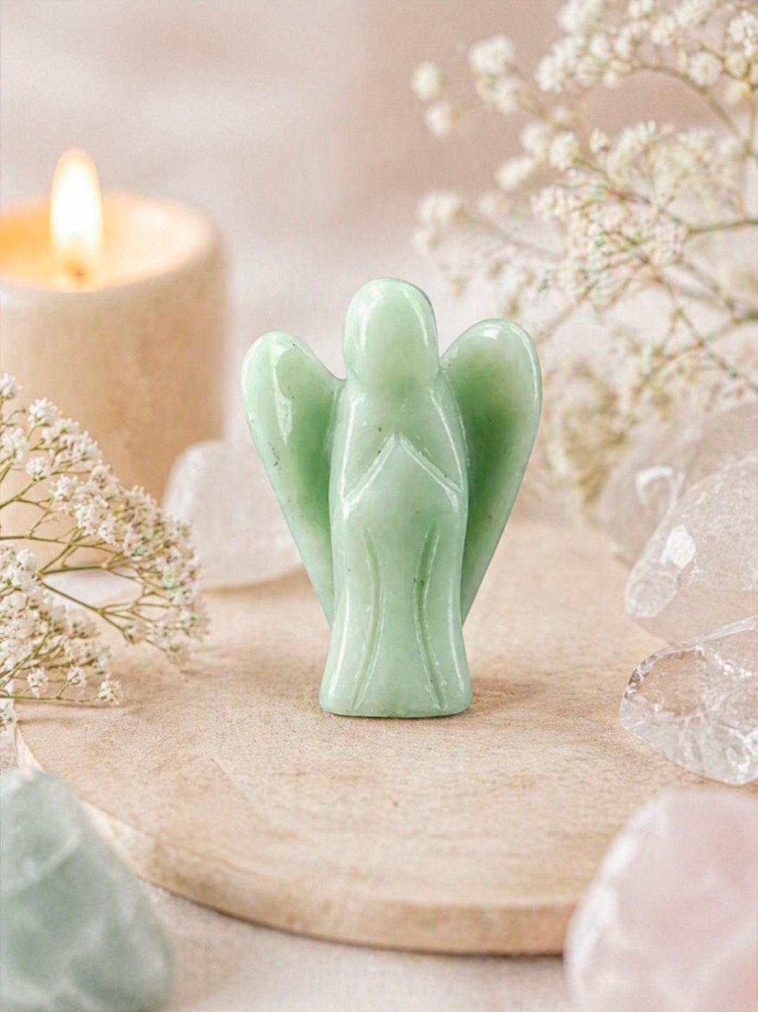 Mintgroen engeltje op een houten dienblad met kaarsen, kristallen en gedroogde bloemen.
