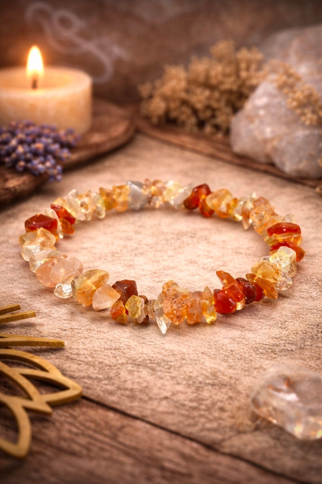 Een armband van barnsteen op rustiek hout, met een kaars en gedroogde bloemen in een warm licht.