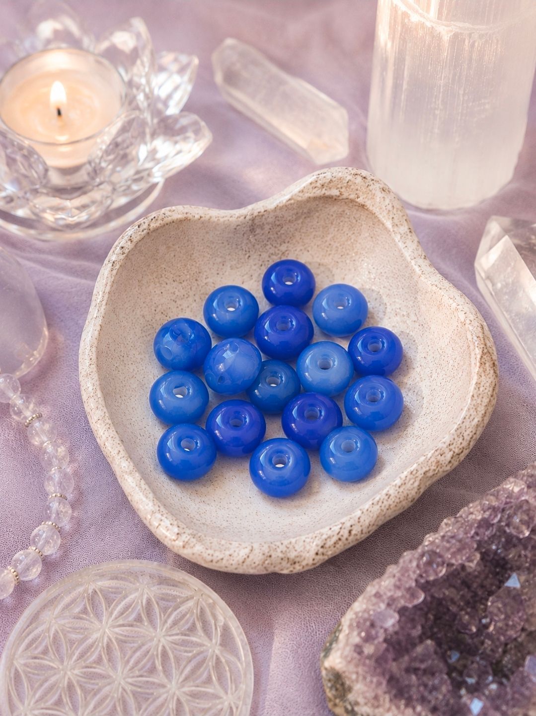 Blauwe, gepolijste kralen in een hartvormige schaal op een pastelkleurige kristallen display.