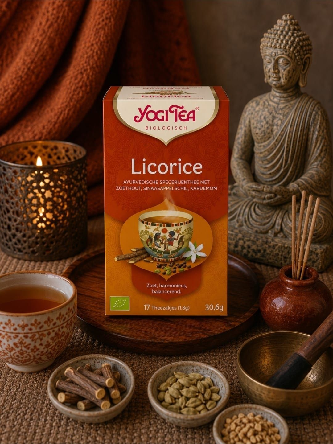 Yogi Tea Dropdoos op een warme tafel met Boeddhabeeldje, kaarsen, thee en specerijen.