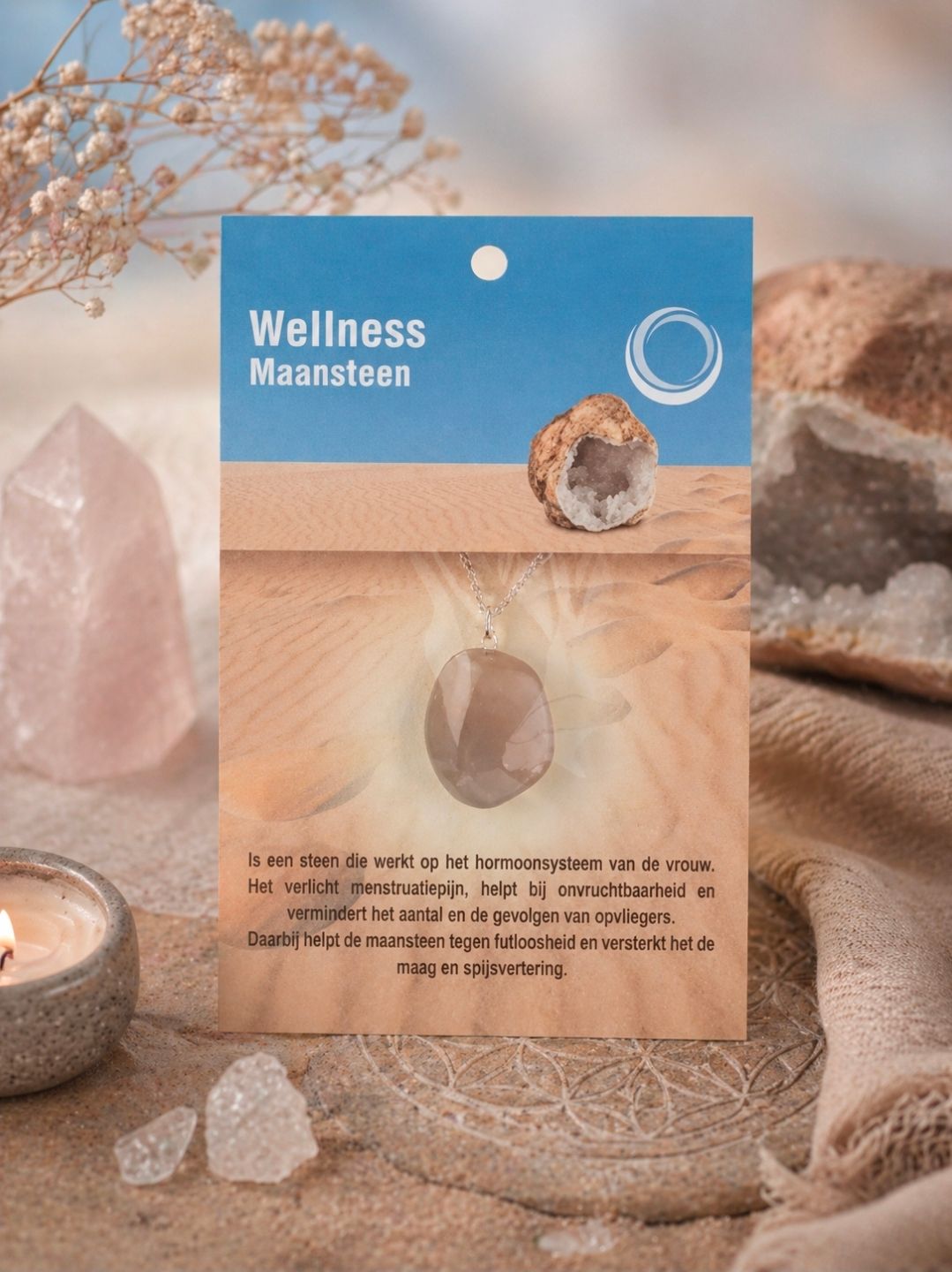 Blauwe en beige wellnesskaart met een kristal, geplaatst tussen kaarsen en stenen in een spa-achtige opstelling.