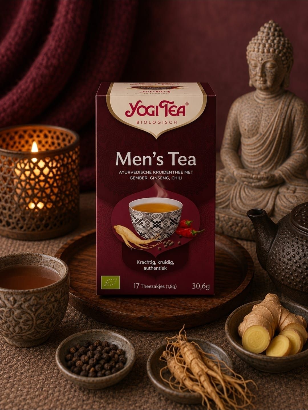 Een doos Yogi Tea herenthee met kruiden en een theekopje op een warme, door kaarsen verlichte tafel.
