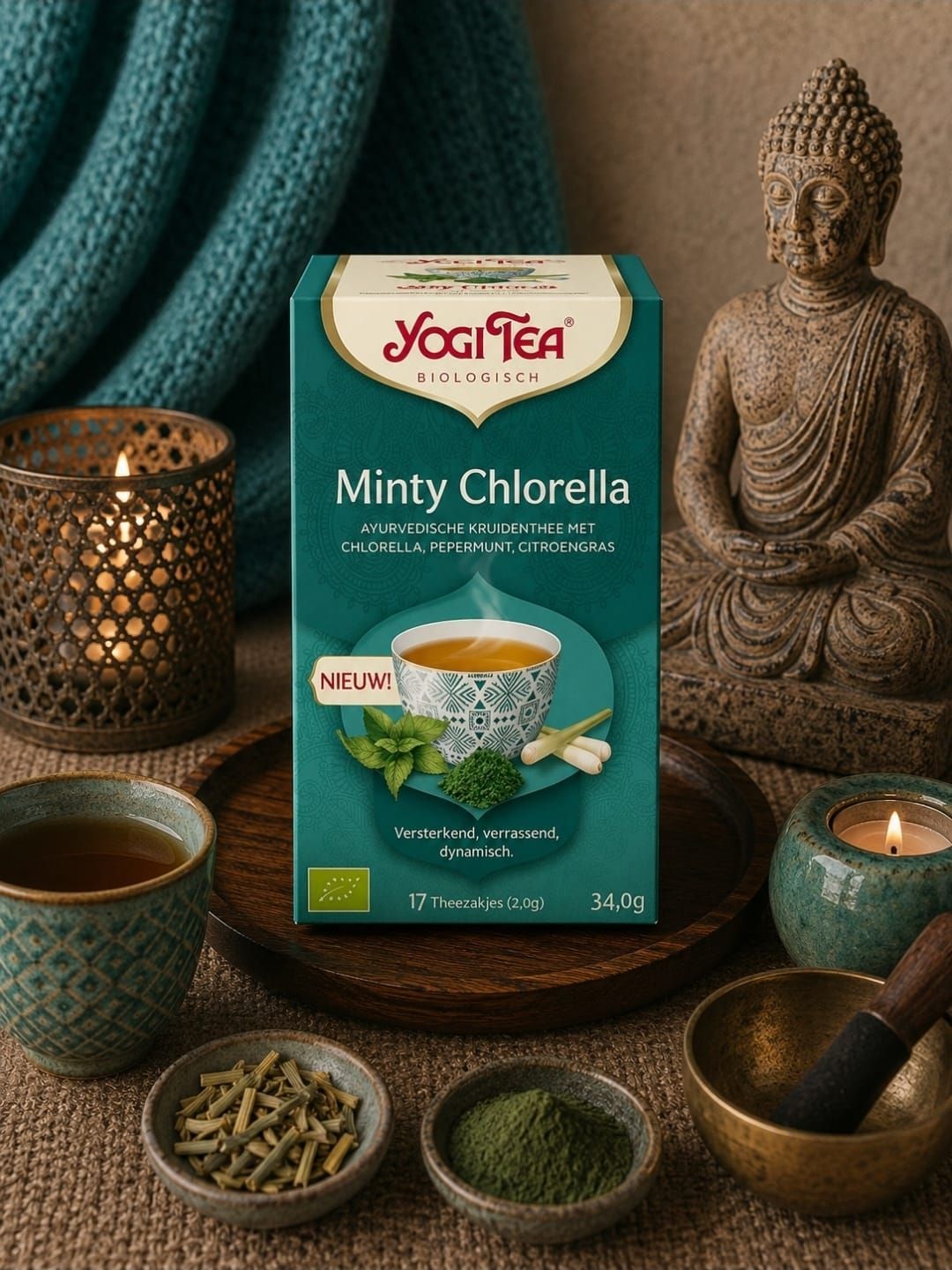 Een doos Yoga Tea Minty Chlorella thee met muntblaadjes en theekopjes op een donkere tafel.