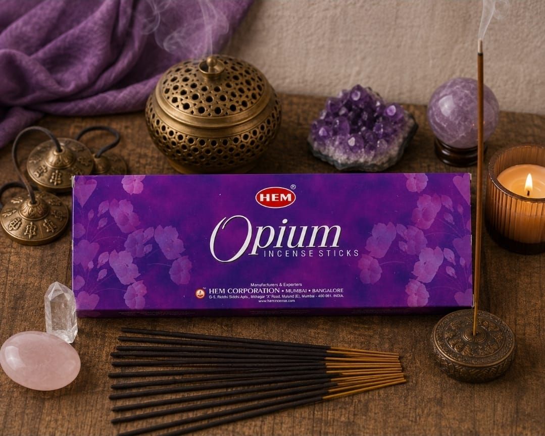 Paarse opium wierookdoos met wierookstokjes, kristallen en kaarsen op een houten altaarachtig oppervlak.