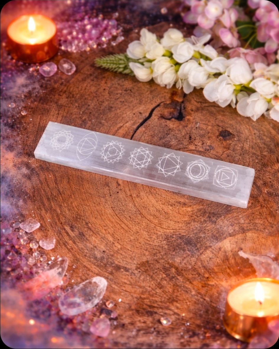 Kristallen toverstaf op een houten plank met kaarsen en witte bloemen in een warme, decoratieve omgeving.