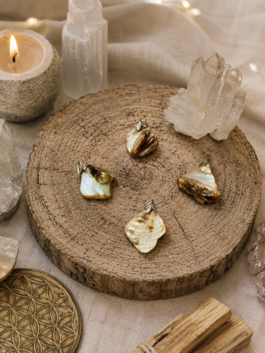 Een spiritueel altaar bij kaarslicht met kristallen, schelpen en een houten plank op een zachte stoffen ondergrond.
