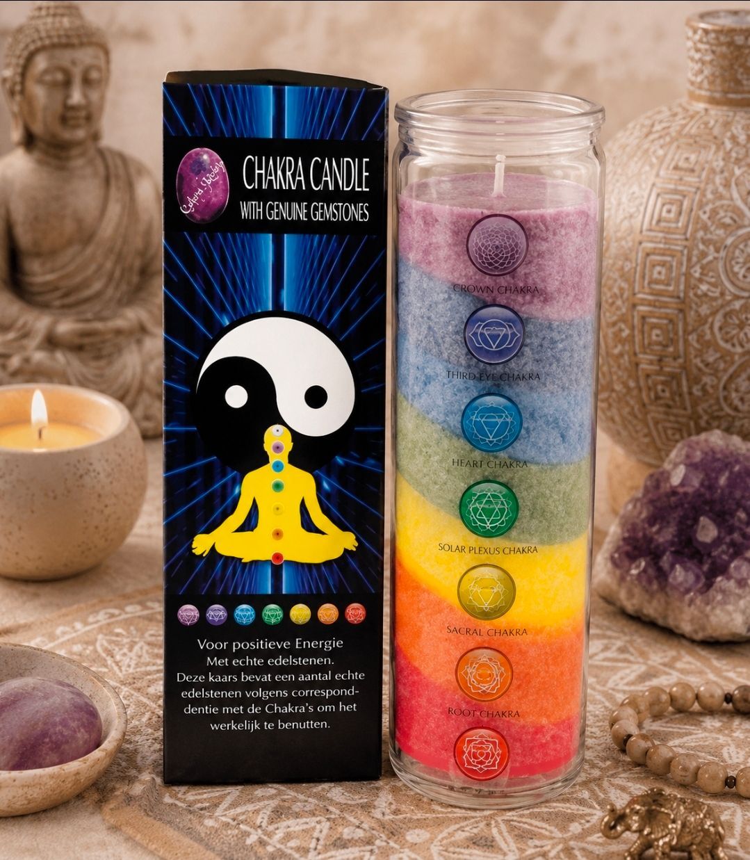Een chakra-helende kaars naast een regenboogchakra-kaars en kristallen decoratie op een warme altaarachtergrond.