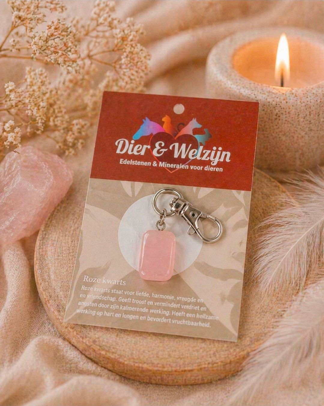 Sleutelhangertje aan een Dier & Weigh-kaartje naast een brandende kaars en gedroogde bloemen.