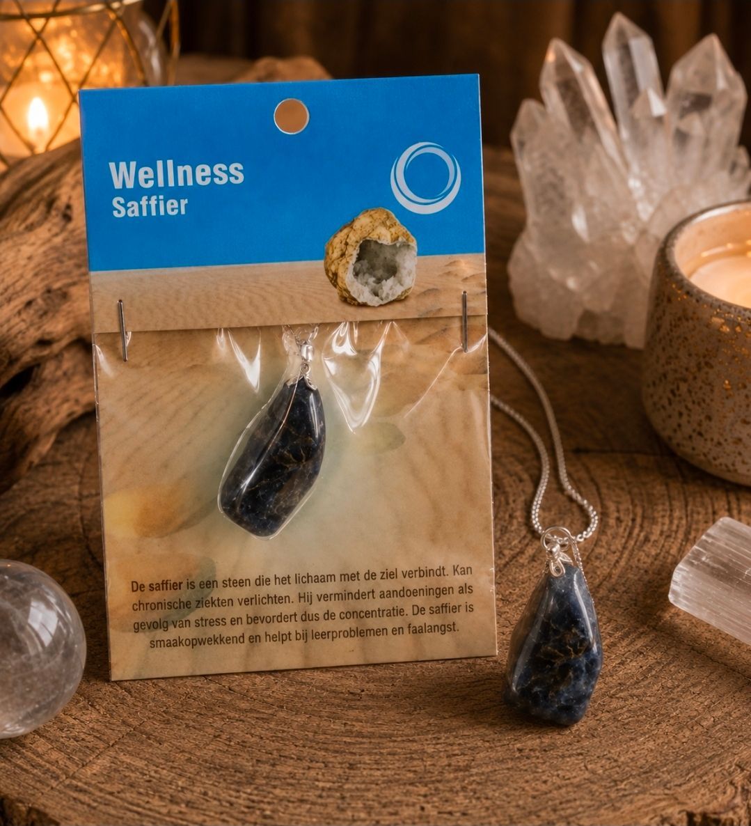 Wellness Safir edelsteenketting in een blauw-beige verpakking, naast kristallen en een kaars.