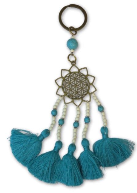 Sleutelhanger met turquoise kwastje, kralen en een goudkleurig geometrisch medaillon.