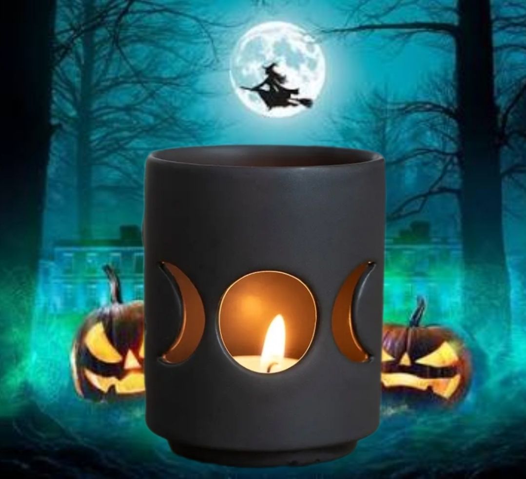 Halloween-kaarsenhouder met gloeiende pompoenen in een griezelig blauw boslandschap, met een volle maan erboven.