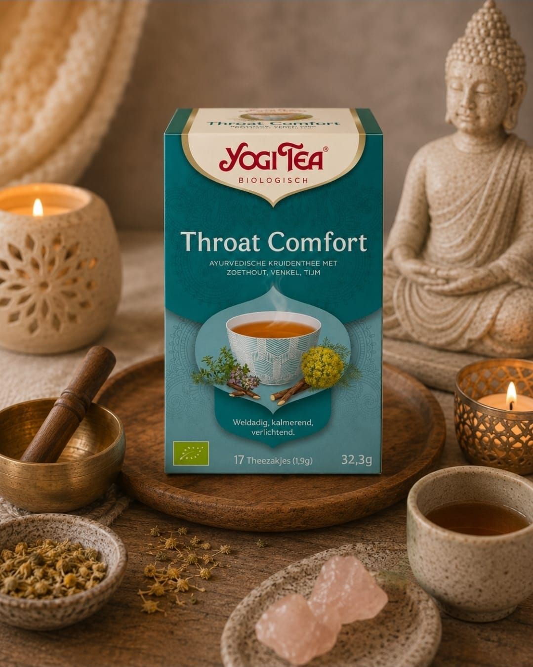 Een doosje Yogi Tea Throat Comfort op een gezellig, spa-achtig altaar met kaarsen, kruiden, een Boeddhabeeldje